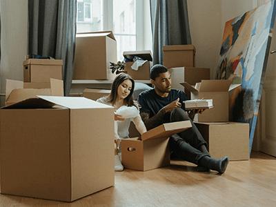 An image of a man and woman moving house for our blog on things you need for a new house